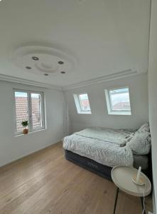a bedroom with a bed and a table and windows at Tolle Wohnung mit Seeblick! in Rorschach