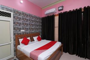 a bedroom with a bed with red pillows at Hotel O Rajshree in Sonīpat