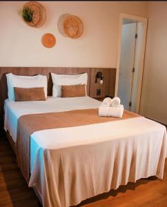 a bedroom with a large bed with two towels on it at Recanto da Orla in Aracaju +30 photos