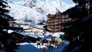a snow covered mountain in front of a building at Résidence Armoise - Studio 3 personnes à Arc 1800 en centre station, proche des pistes et des commerces, dans le village des Villards MAE-1847 in Arc 1800