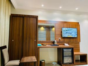 a hotel room with a desk and a window at Itlalat Uhud Hotel - فندق إطلالة احد in Medina