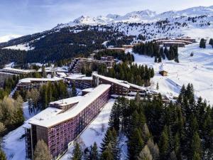 een resort in de sneeuw met bergen op de achtergrond bij Résidence Belles Challes - Studio 4 personnes à Arc 1800 skis aux pieds et proche des commerces dans le village du Charvet MAE-1962 in Arc 1800