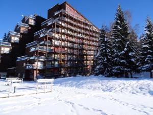 een gebouw in de sneeuw met bomen en sneeuw overdekte grond bij Résidence Belles Challes - Studio 4 personnes à Arc 1800 skis aux pieds et proche des commerces dans le village du Charvet MAE-1962 in Arc 1800 +12 foto's