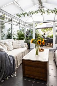 ein Wohnzimmer mit einer Couch und einem Tisch mit Blumen in der Unterkunft Sandringham House in Saint Helier Jersey