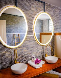 a bathroom with two sinks and two mirrors at habitation luna martinique in Chambort