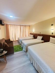a hotel room with three beds and a couch at Hotel La Estancia in Cabudare +16 photos