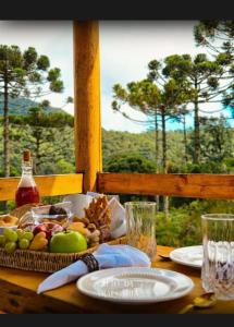 a wooden table with a basket of fruit on it at Cabana Araucária in Bom Retiro