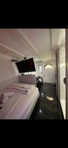 a bedroom with a white bed and a room with a door at Secret intime in Chalon-sur-Saône