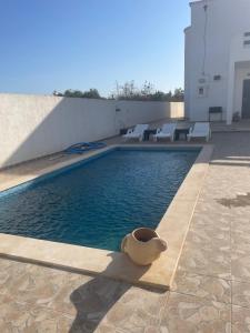 a swimming pool with a pot on the side of a building at Villa doullia in El Mây