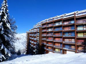 a large building in the snow with a tree at Résidence Nova - Studio 2 personnes, proche des pistes et des commerces, au cœur de la station d’Arc 1800 dans le village des Villards MAE-2572 in Arc 1800