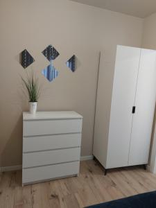 a room with a white cabinet and a dresser at Apartament MK&58 in Kielce