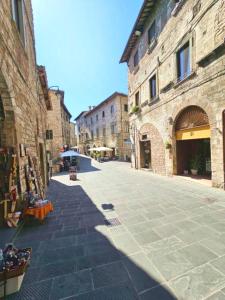 an empty street in an old town with buildings at Dimora dei Consoli in Gubbio