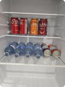 a refrigerator filled with cans of coca cola and soda at Charming Suite in Cambridge