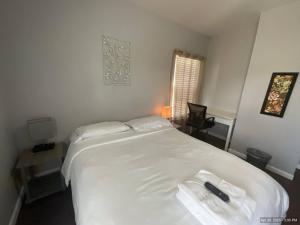 a bedroom with a white bed with two towels on it at Cozy private room - 11 mins to Downtown & Airport in Birds Nest
