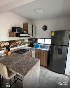 a kitchen with a stainless steel refrigerator and a counter at Apartamento de Vacaciones con Piscinas y Jacuzzi - Perfecta para Grupos - By Molca Travel in Armenia +3 photos