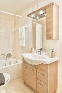 a bathroom with a sink and a tub and a toilet at Artemida Pansion Georgioupolis in Kournás +18 photos