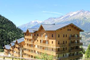 un grande condominio con montagne sullo sfondo di Résidence Le Cheval Blanc - LE CHEVAL BLANC - CB30 MAE-3182 a Modane
