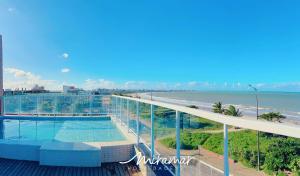 a swimming pool on top of a building next to the beach at Paradise Beira Mar-Miramar Hospedagens in Nossa Senhora do Livramento