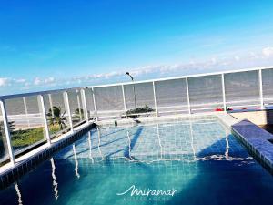 a swimming pool with the ocean in the background at Paradise Beira Mar-Miramar Hospedagens in Nossa Senhora do Livramento