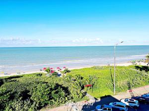 a view of a beach with parked cars and the ocean at Paradise Beira Mar-Miramar Hospedagens in Nossa Senhora do Livramento