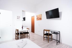 - un salon avec un lit, une table et une télévision dans l'établissement Syntagma square 25sqm Cozy studio, à Athènes