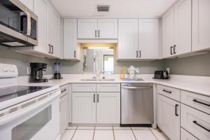 a white kitchen with white cabinets and appliances at Phoenix I 1144 condo in Orange Beach