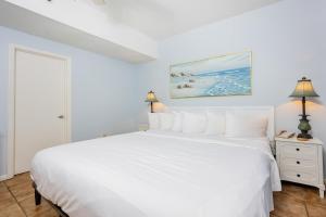 a white bedroom with a white bed and a window at Phoenix I 1144 condo in Orange Beach