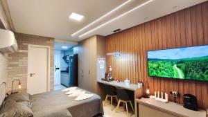 a bedroom with a large flat screen tv on a wall at Açores Praia de Tamandaré - À Beira-Mar in Praia dos Carneiros