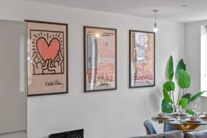 a group of framed pictures on a wall in a living room at 2 Bed Modern Apartment in City Centre Birmingham in Birmingham +28 photos