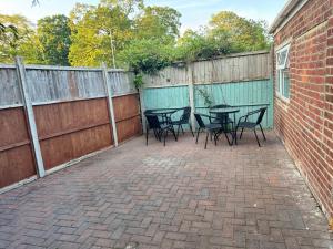 a patio with tables and chairs next to a fence at Modern Studio Appartment in Cheltenham