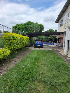a blue car is parked under a garage at Villa maría rozo in Palmira
