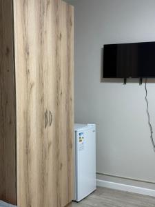 eine Holztür neben einem Kühlschrank in einem Zimmer in der Unterkunft Фучика 50 in Zhezdi