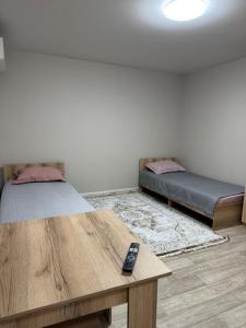 Zimmer mit 2 Betten und einer Fernbedienung auf dem Tisch in der Unterkunft Фучика 50 in Zhezdi