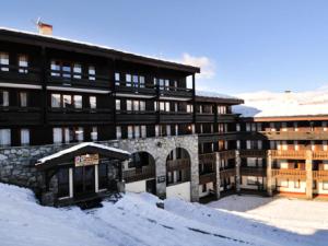 a large building with snow in front of it at Résidence Backgammon - LE BACKGAMMON MAE-3560 in Les Coches