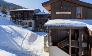 a building covered in snow with a snow covered slope at Résidence Backgammon - LE BACKGAMMON MAE-3560 in Les Coches +5 photos