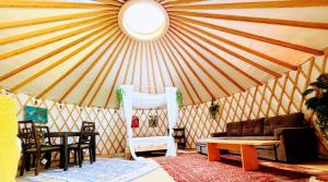 a yurt with a couch and a table and chairs at Dreaming SkyLake Yurt Waterfront in Red Bay
