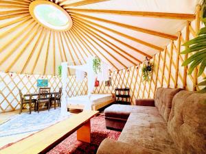 a room with a couch and a table in a yurt at Dreaming SkyLake Yurt Waterfront in Red Bay