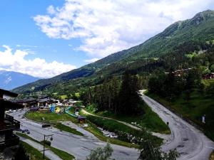 a winding road in a valley with a mountain at Résidence Terrasse - La Terrasse 11 - Joli appartement, skis aux pieds MAE-5054 in Valmorel