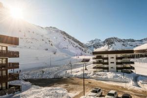 a ski resort with a snow covered slope and a building at Résidence Roches Rouges A - Charmant, chaleureux, pied des pistes MAE-3749 in Tignes
