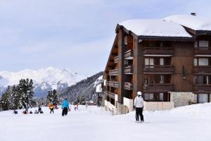 Mâcot La PlagneにあるRésidence Onyx - Studio fonctionnel · Accès direct aux pistes ·Vue pistes · Balcon MAE-3777の山小屋の隣の雪上スキー +4枚の写真