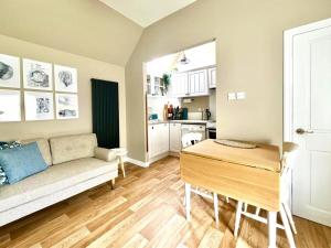 a living room with a couch and a table at Seatown Cottage - Stone's throw from beach in Lossiemouth