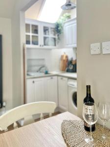 a table with a bottle of wine and two glasses at Seatown Cottage - Stone's throw from beach in Lossiemouth