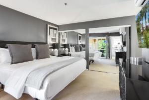 ein Schlafzimmer mit einem großen weißen Bett und einem Klavier in der Unterkunft Chic Downtown Bungalow in Palm Springs + 18 Fotos