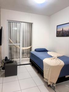 a bedroom with a bed and a large window at Quarto e sala piscina aquecida in Brasilia
