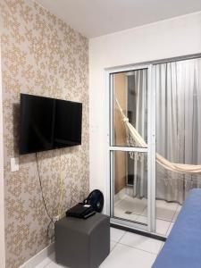 a room with a flat screen tv on a wall at Quarto e sala piscina aquecida in Brasilia
