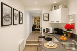 une cuisine avec un évier et un comptoir avec des tabourets dans l'établissement LE MARAIS-SAINT MARTIN working & living, à Paris