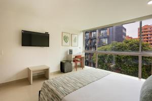 a hotel room with a bed and a large window at Hotel Suite Comfort in Medellín