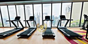 a gym with several treadmills in front of a large window at Kuala Lumpur Luxury Suites By Majestic Residence in Kuala Lumpur