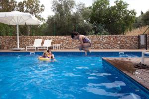 a woman jumping into a swimming pool with a child at Villa Pnai in Rosh Pinna