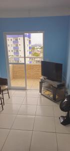 a living room with a flat screen tv on a table at Apartamento Splendore in Bertioga +6 photos